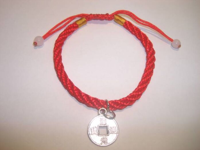 Red thread bracelet with a rare coin to bring good luck